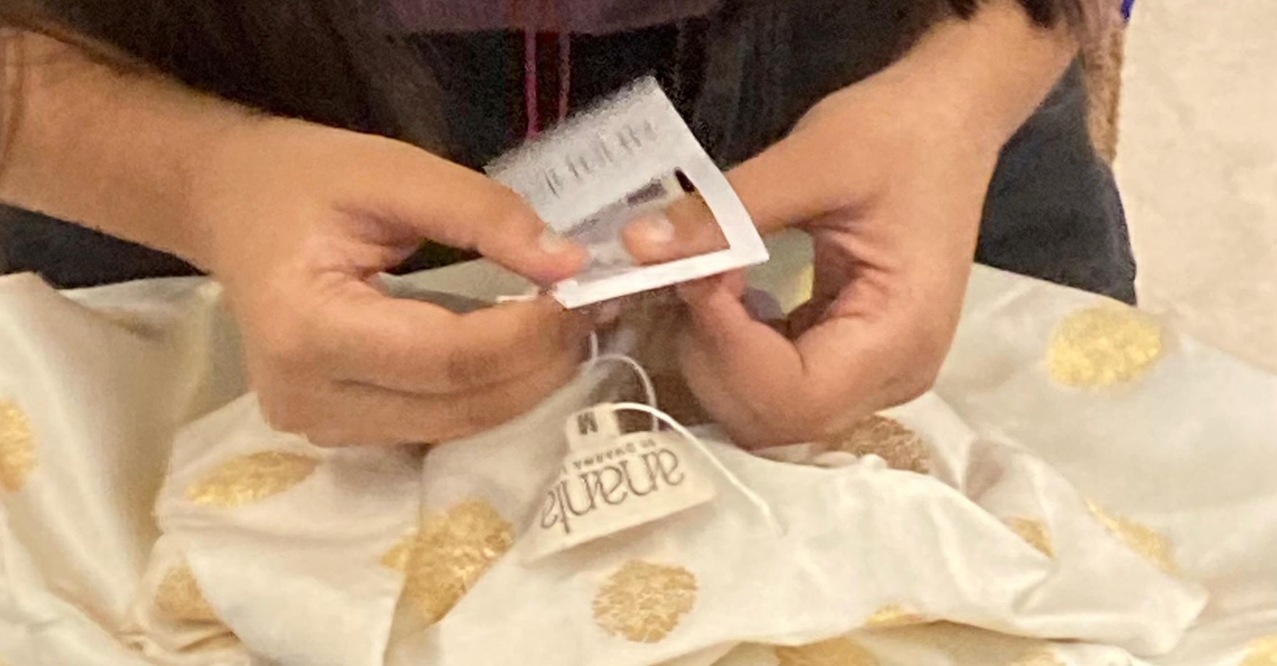 The finished tag being attached to a garment